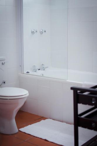 a bathroom with a toilet and a tub and a sink at Paradiso Guesthouse & Self-catering Cottage in Cape Town