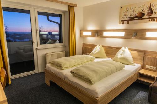 a bedroom with a bed and a large window at Landhotel Haagerhof in Aigen im Mühlkreis
