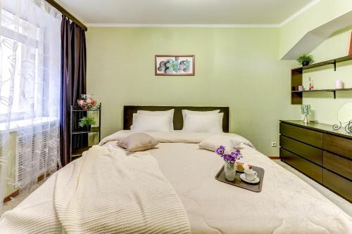 Un dormitorio con una gran cama blanca con flores. en Апартаменты Веста на Фонтанке, en San Petersburgo