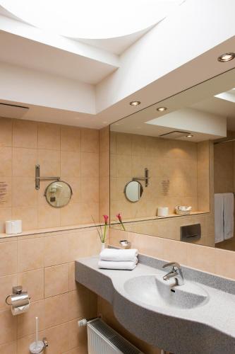 a bathroom with a sink and a large mirror at Hollywood Media Hotel am Kurfürstendamm in Berlin