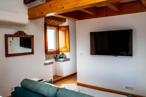 a living room with a couch and a flat screen tv at Casa Gil Vicente in Almada