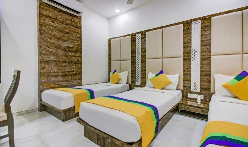 a bedroom with two beds and a brick wall at Hotel Magnet TERMINAL-2 in Mumbai