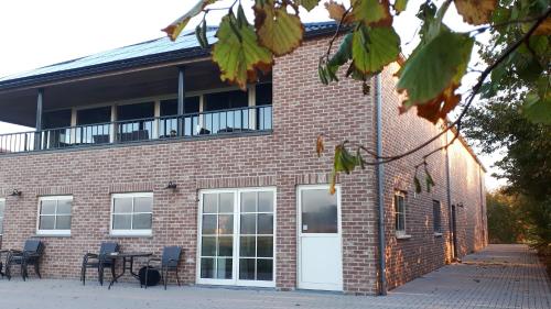 a brick building with white doors and tables and chairs at Klein Cambron in Hulst