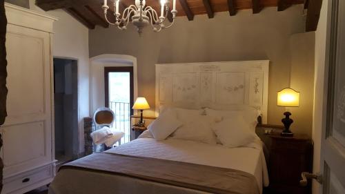 a bedroom with a large white bed with a chandelier at Villa Migliorati in Vaiano