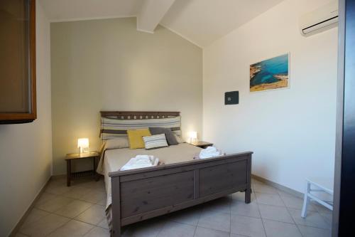 a bedroom with a bed with two lamps on it at Riva Sea Apartments in Castellammare del Golfo