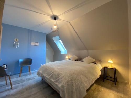 een slaapkamer met een groot bed met blauwe muren bij Chez Mary Elise in Le Claux