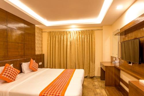 a hotel room with a bed and a flat screen tv at Hotel Yellow Pagoda Pokhara in Pokhara