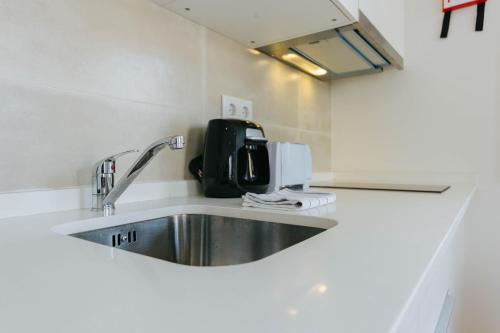a kitchen with a sink and a microwave at RENT4REST LISBON DOWNTOWN TINY STUDIO Apartments in Lisbon