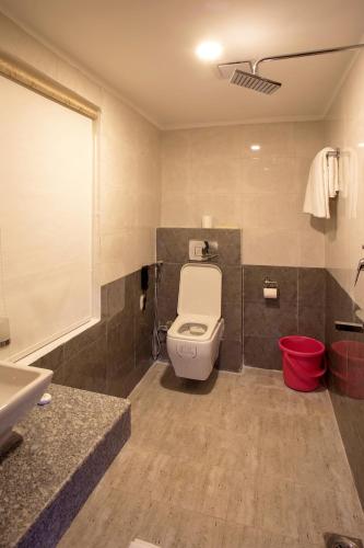 a bathroom with a white toilet and a sink at Hotel Yellow Pagoda Pokhara in Pokhara