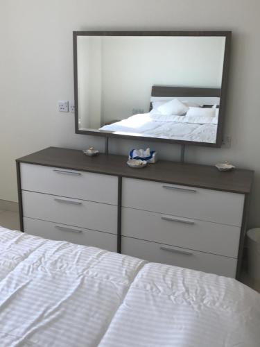 a mirror on a dresser in a bedroom with a bed at Obhur Residence 2 in Obhor