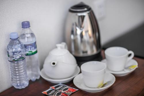 a table with a tea pot and cups and bottles of water at Hotel Minor in Samarkand