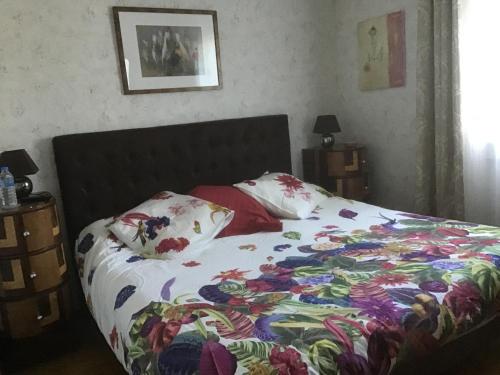 a bed with a colorful comforter and pillows on it at Clos des Cailloux in Prades-le-Lez