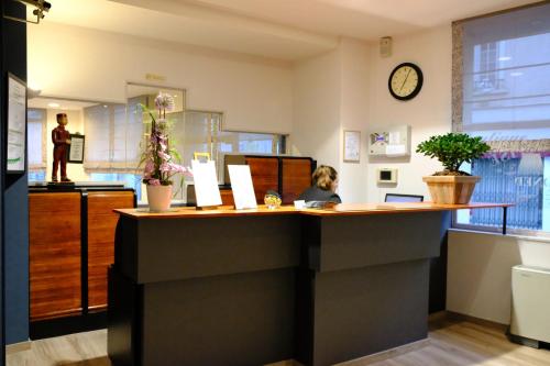 a woman sitting at a counter in a office at Hotel Continental in Angers
