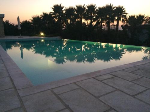 a swimming pool with a sunset in the background at WHITE POOL 4P Matino - Gallipoli in Matino
