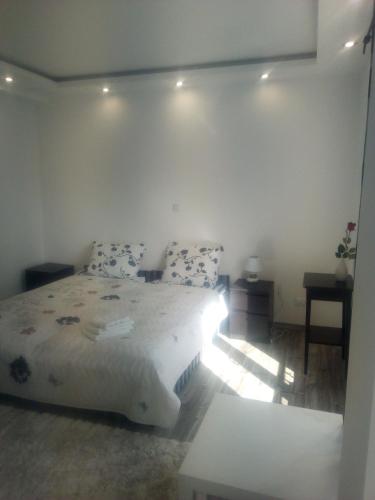 1 dormitorio con 1 cama grande y 1 mesa en Rozinka apartman, en Dunaújváros