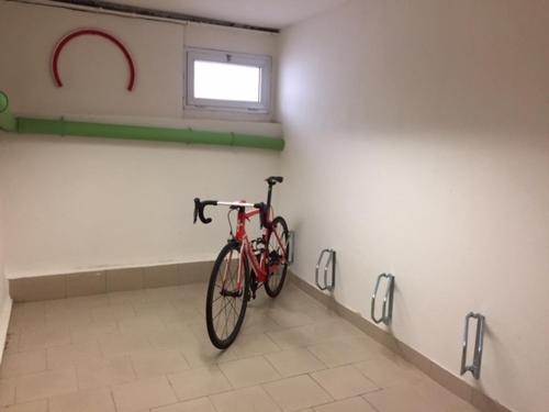 a red bike parked in a room with a wall at Bed & Bike Ferrara in Ferrara