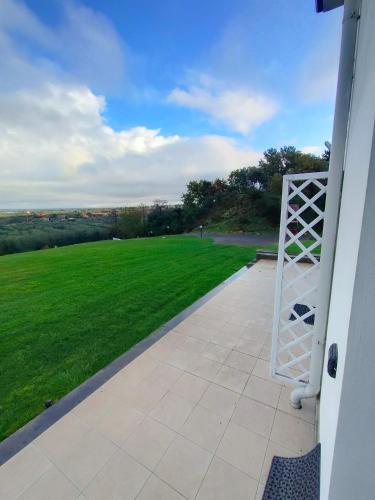 a porch with a view of a field of grass at la staccionata bianca in Viterbo
