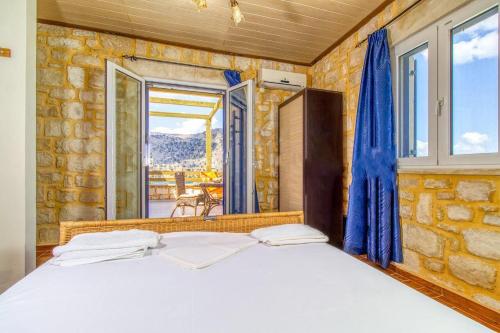 a bedroom with a bed and a stone wall at Lake Villas II in Mouríon