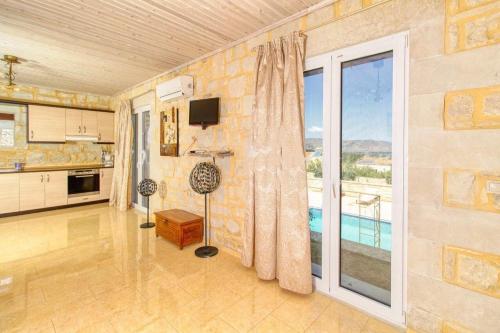 a living room with a kitchen and a large window at Lake Villas II in Mouríon