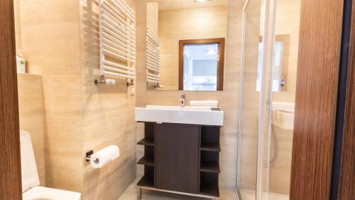 a bathroom with a sink and a shower at VacationClub – Platan 2E Apartament 19 in Świnoujście