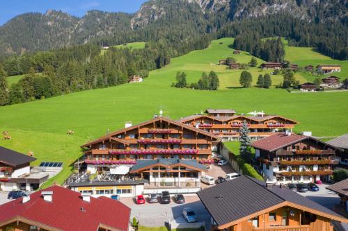 an aerial view of a resort with a green hill at Hotel Alphof Alpbach in Alpbach