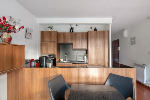 une cuisine avec des armoires en bois et une table et des chaises dans l'établissement Les Embruns, à Saint-Cyprien