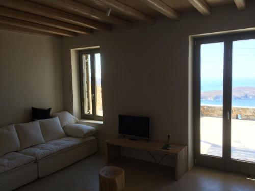 a living room with a couch and a tv at deep blue villas, Serifos in Serifos Chora