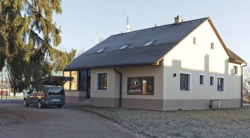 une maison avec une voiture garée devant elle dans l'établissement Penzion&Pizzerie U Massima, à Vyškov