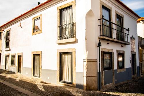 アルマダにあるCasa Gil Vicenteの窓とバルコニー付きの白い建物
