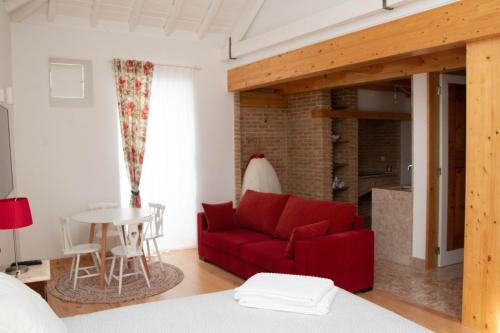 a living room with a red couch and a table at Casa Gil Vicente in Almada