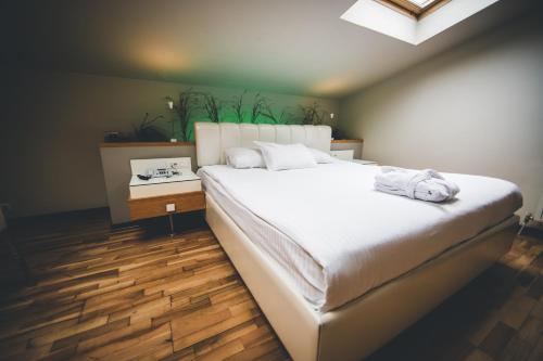1 dormitorio con 1 cama blanca grande y suelo de madera en No:19 Boutique Hotel, en Ankara