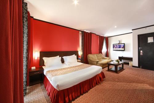 Habitación de hotel con cama y pared roja en Manhattan Avenue Hotel en Dubái