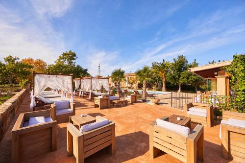 a patio with a bunch of lounge chairs and a pool at Agroturismo Es Quatre Cantons in Binissalem