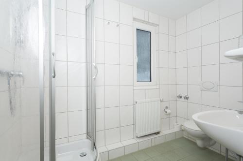 a white bathroom with a toilet and a sink at Sportpark Rabenberg in Breitenbrunn