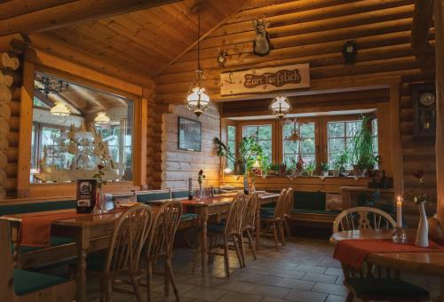 a restaurant with wooden walls and tables and chairs at Gaststätte und Pension Zum Torfstich in Hundshübel