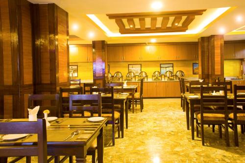 a dining room with tables and chairs and a restaurant at Hotel Yellow Pagoda Pokhara in Pokhara