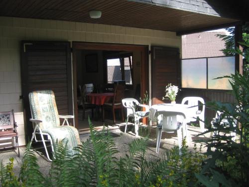 eine Terrasse mit einem Tisch und Stühlen sowie ein Esszimmer in der Unterkunft Charming Holiday Home in Liebenscheid by Forest in Liebenscheid