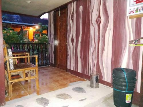 a screened in porch with a chair and a table at BING-VICE Tourist Inn in San Vicente
