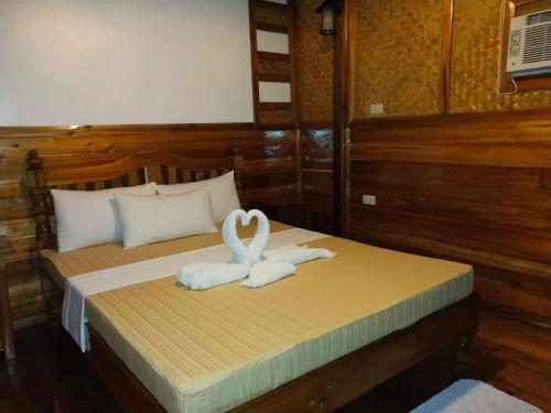 two white swans are sitting on a bed at BING-VICE Tourist Inn in San Vicente