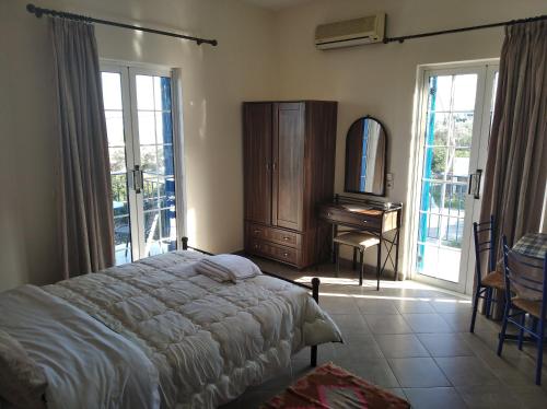 a bedroom with a bed and a dresser and a mirror at Evgenia Rooms in Skala