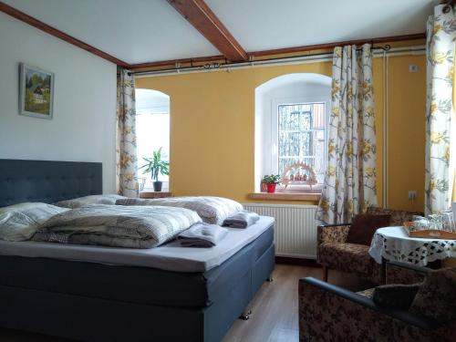 Schlafzimmer mit einem Bett, einem Tisch und einem Fenster in der Unterkunft Gasthaus Ruebenau in Rübenau
