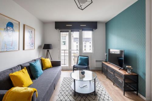 un salon avec un canapé et une télévision dans l'établissement Le Sphinx by Cocoonr, à Nantes