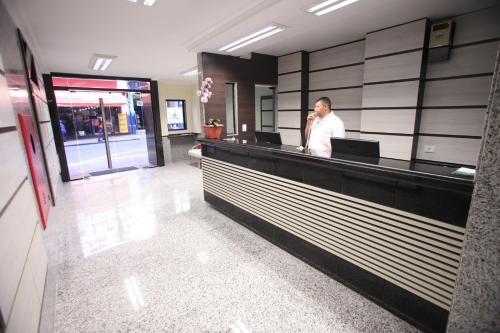 a man talking on a cell phone in a lobby at Soneca Plaza Hotel in Sao Paulo