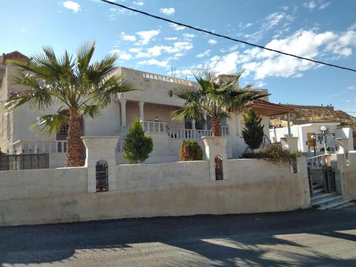 a house with palm trees in front of it at Horizon in Wadi Musa