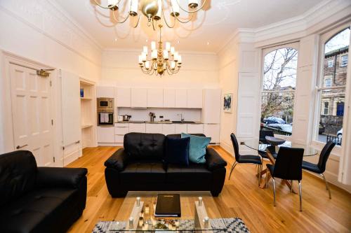 a living room with a black couch and a table at Beaufort House Apartments from Your Stay Bristol in Bristol