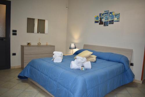 a bedroom with a blue bed with towels on it at B&B Notte Stellata in Frattamaggiore