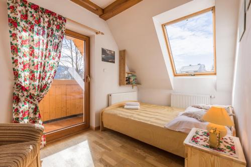 ein kleines Schlafzimmer mit einem Bett und einem Fenster in der Unterkunft Apartament Słoneczny Zakopane in Kościelisko