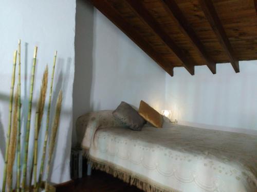 a bedroom with a bed with two pillows on it at Room El Pilarillo in Alcaucín