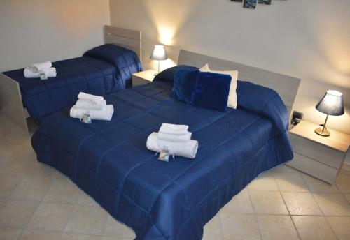 a bedroom with a blue bed with towels on it at B&B Notte Stellata in Frattamaggiore