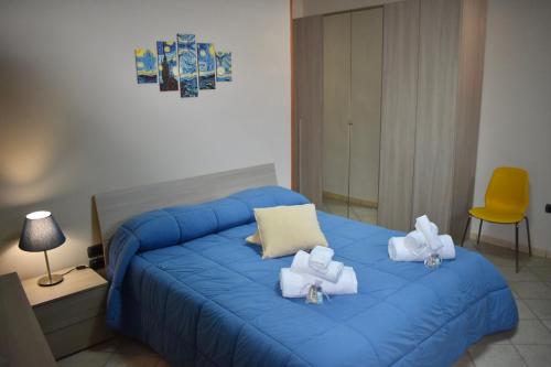 a bedroom with a blue bed with towels on it at B&B Notte Stellata in Frattamaggiore